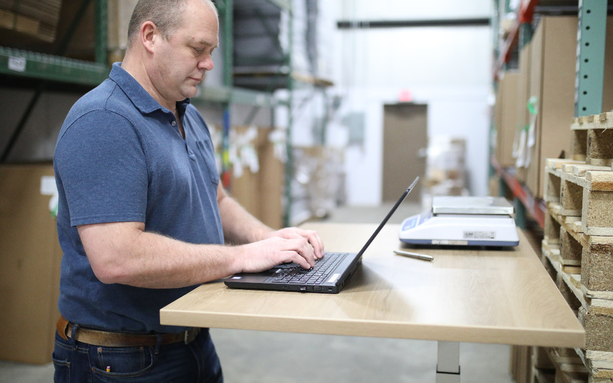 Man using laptop for manufacturing IT work.