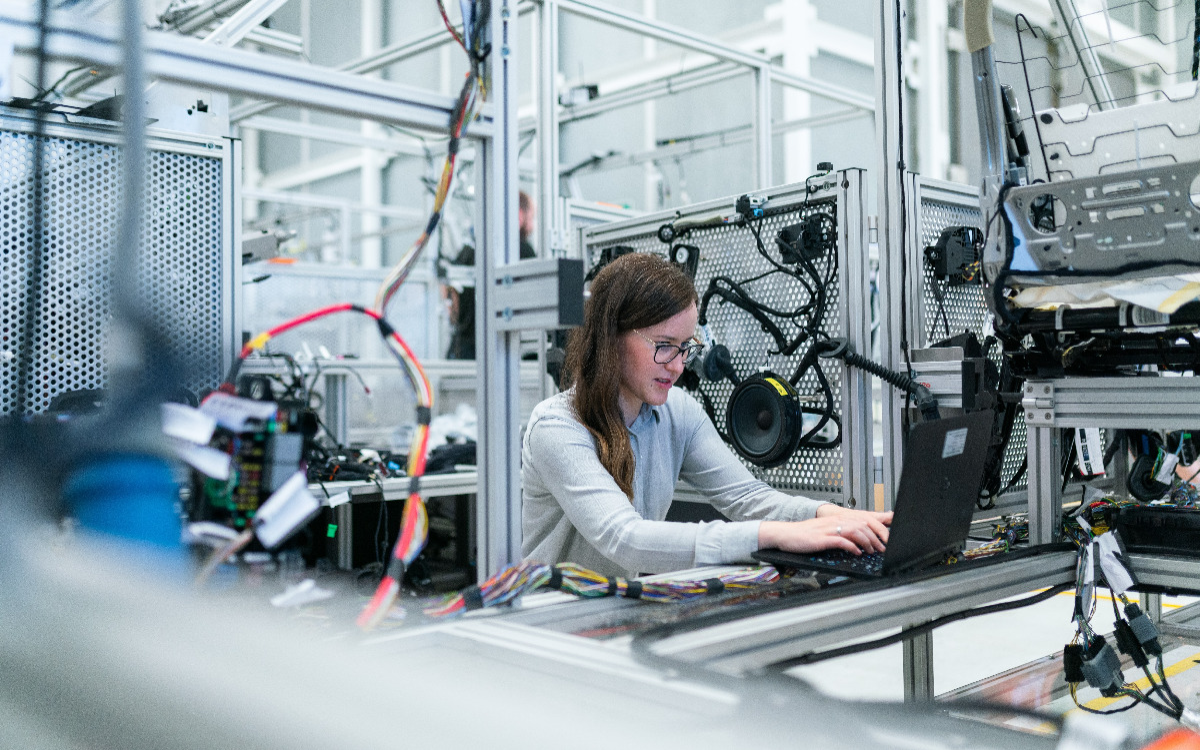 Woman using laptop in building to provide IT support.