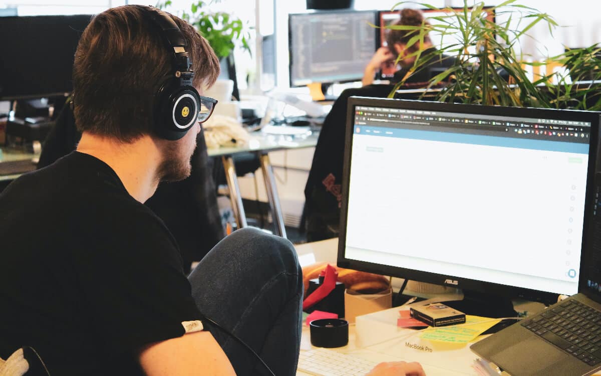 Man sitting in front of computer offering outsourced IT help desk services.