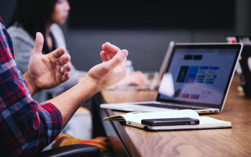 Laptop on table in front of people discussing co-managed IT