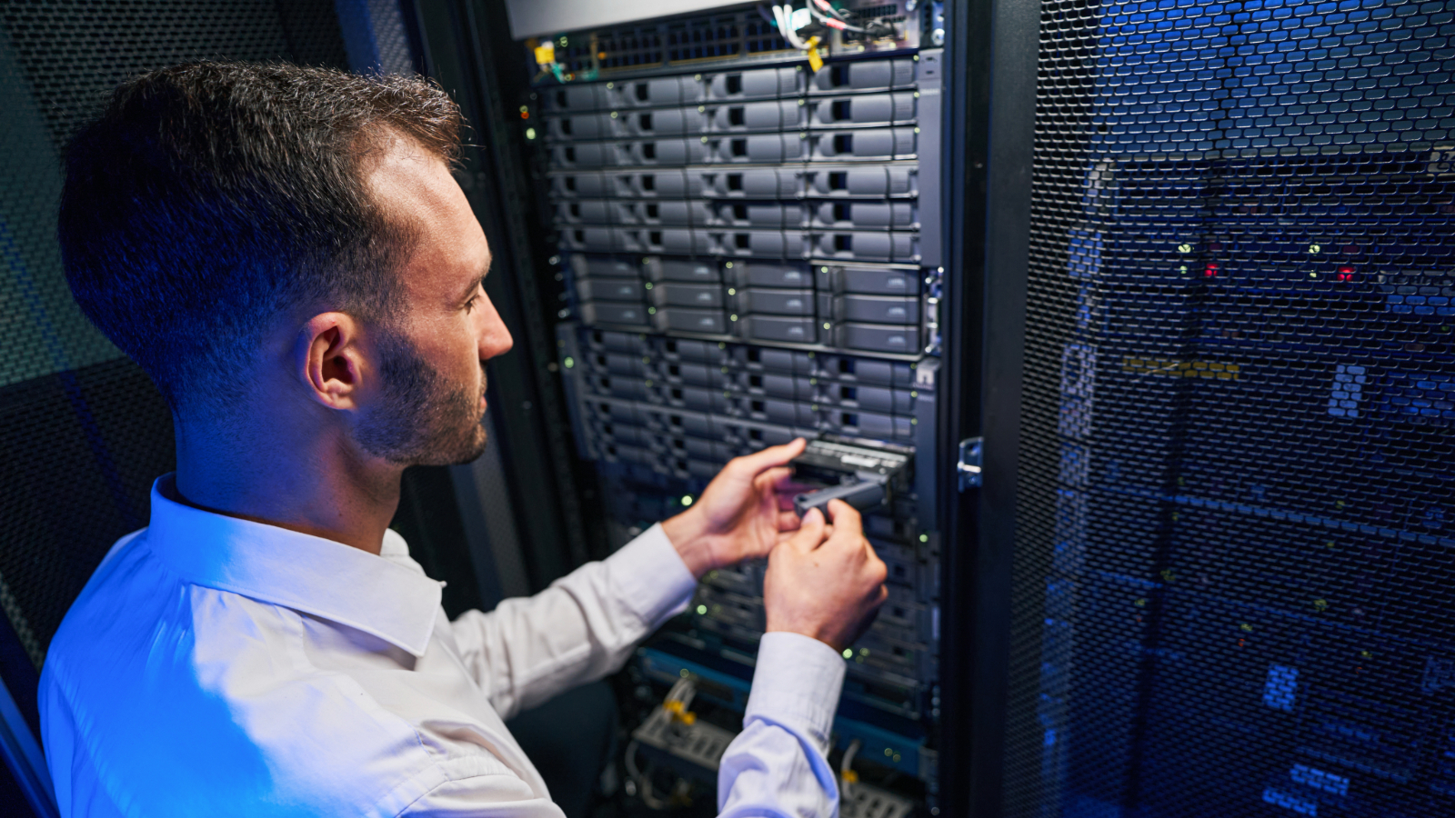 An IT support agent from an MSP doing repairs in a computer server room.