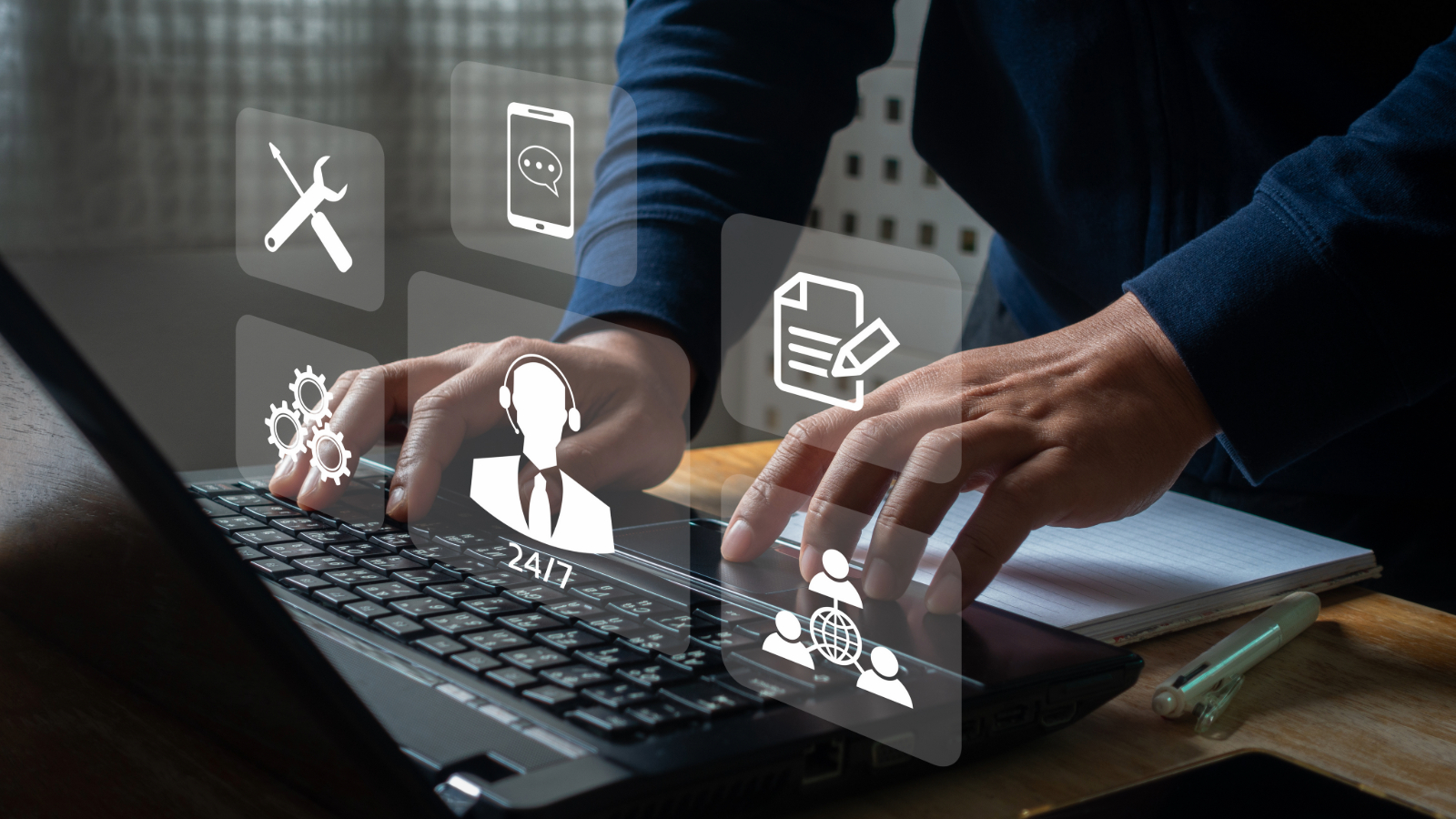 Person typing on a laptop with digital icons representing desktop support services, including 24/7 help desk, tools, chat, and device management.