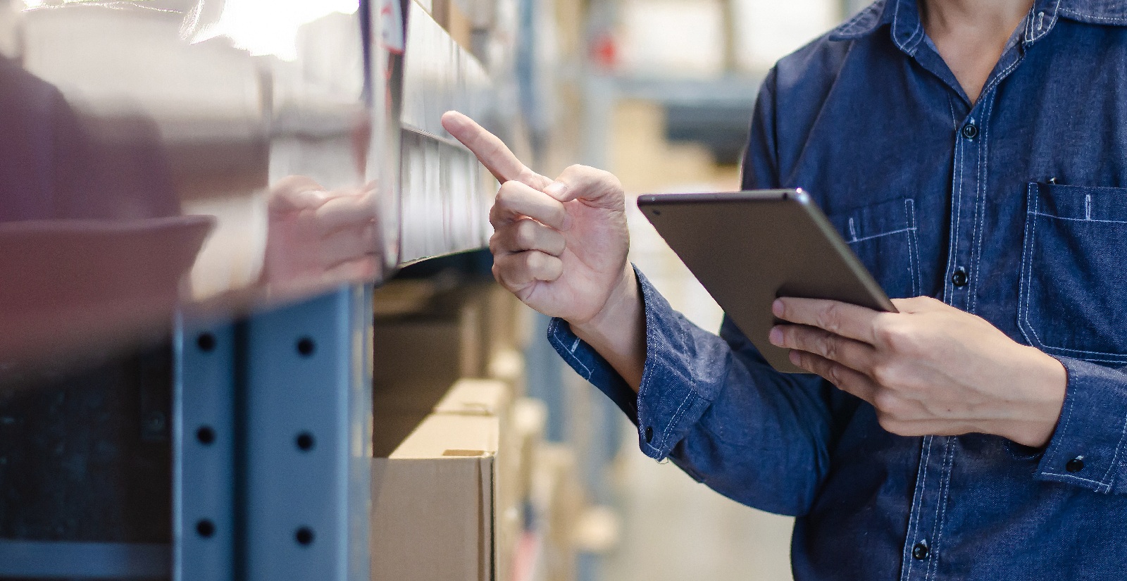 Worker reviewing inventory with a tablet, representing MSP vendor management improving oversight and control of vendor operations.